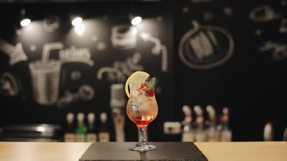 A Barman Putting Straws Into Red Mojito