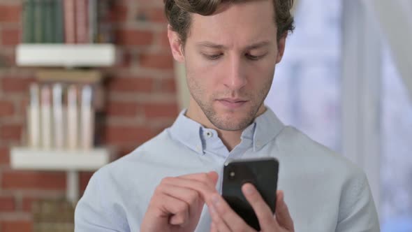 Portrait of Young Man Celebrating Success on Phone