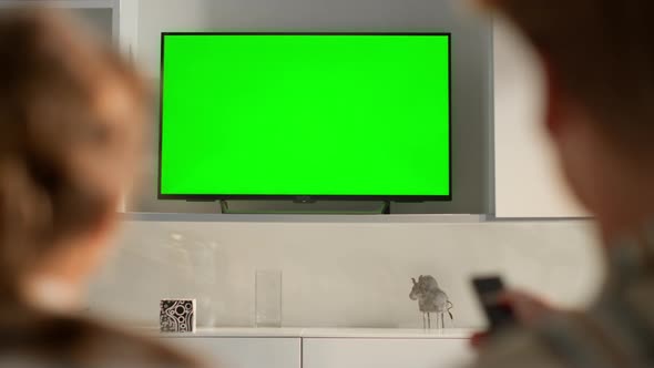 Couple Switching Green TV Set