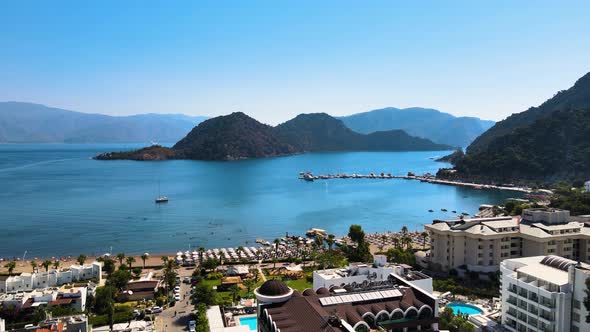 Flying drone over the resort town and hotels against the background of the mediterranean sea blue sk