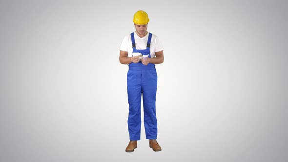 Builder Counting Money Standing on Gradient Background.