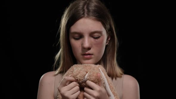 Front View Portrait of Sad Teenage Caucasian Girl Looking at Camera Holding Soft Toy