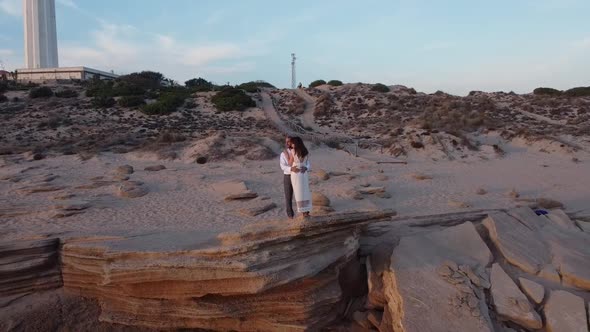 Loving bride and groom on seashore at sunset