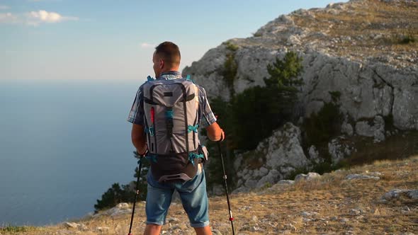 Young Man is Hiking on Mountains and Resting on Sea Coast in Autumn Day Spbd