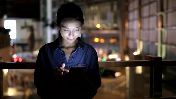 Woman use of smart phone in city at night