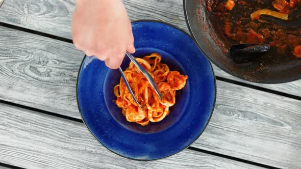 Hand with Tongs, Seafood Pasta.