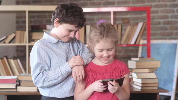 Students in class stand near Desk and look smartphone. Technologies in education