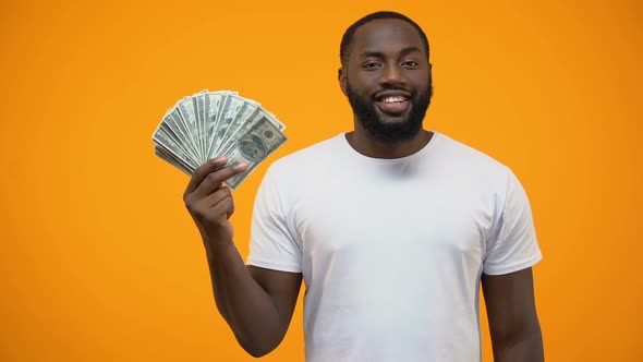 Afro-American Man Holding Bunch of Dollars and Showing Thumbs Up, Start-Up