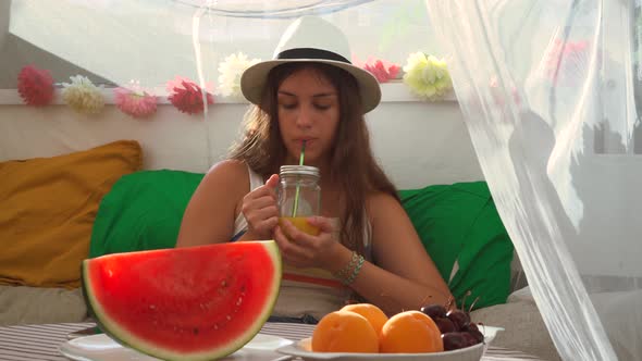 Woman drinking fresh juice from glass jar