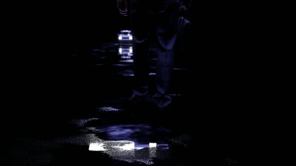 Man Walking Towards Car On Wet Road At Night