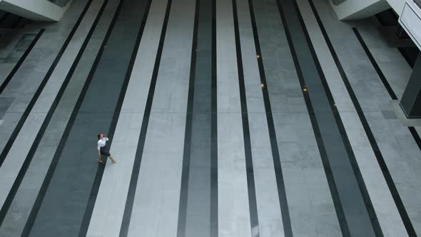 Top view. Executive businesswoman walks through empty lobby business center