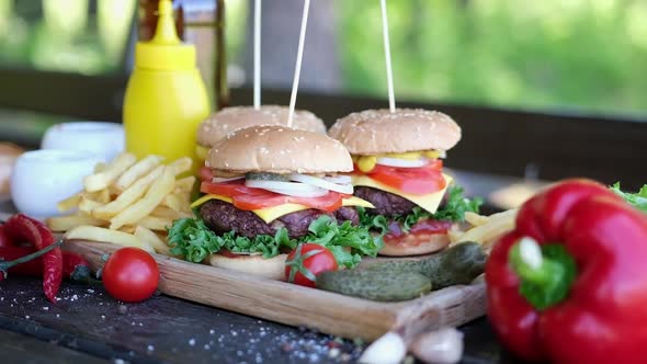 Cheeseburgers Served with French Fries on a Board Outdoors