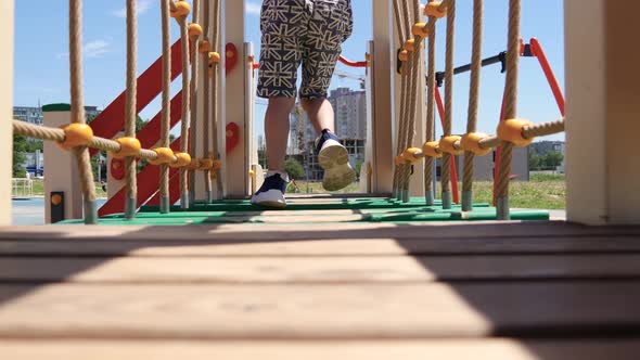 Feet of a Small Child Close-up. Happy Joyful Boy Walking on the Playground and Rolling Down the