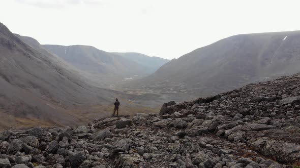 A Lonely Traveler Looks Out From the Mountain Top Over the Valley