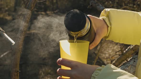 Warm Tea Poring Out From a Thermos in Cup