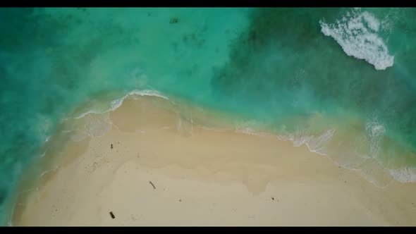 Aerial top down panorama of tranquil shore beach trip by blue green lagoon and white sandy backgroun