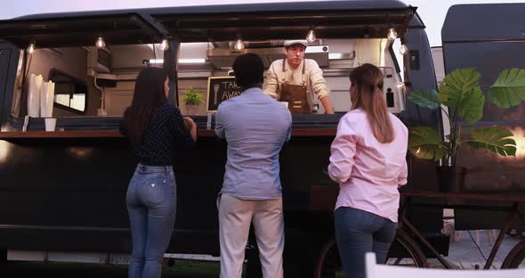 Multiracial people ordering gourmet meal in front of food truck outdoor