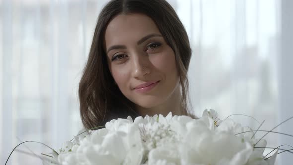 Portrait of Happy Young Woman with Flowers