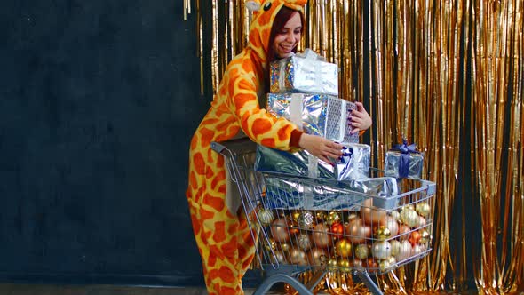 Happy Woman with Trolley with Christmas Presents and Baubles