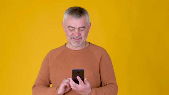 Handsome adult man uses smartphone texting messages in social media