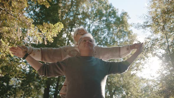 Happy Old Enjoying Autumn Day in Park. Senior Man Flirting with Elderly Woman. 