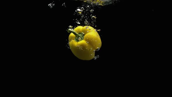 Fresh Vegetables Yellow Bell Pepper Falling Into Water With Lot Of Air Bubbles Black Background