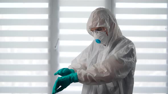 Pandemic Covid-19. Portrait of a Virologist in a Protective Suit. A Male Epidemiologist Is Ready To