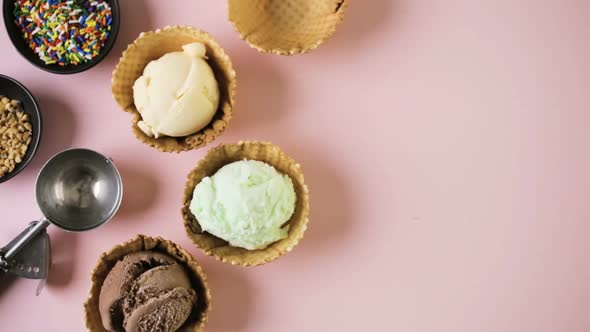 Waffle ice cream bowls with scoops of ice cream on a pink background.