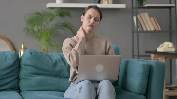 Woman with Laptop Having Neck Pain on Sofa