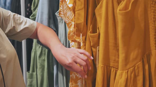 A Girl Chooses a Dress in the Store