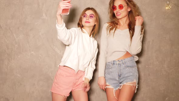Two Carefree Young Girls Going Crazy. Women Dancing in Hipster Summer Jeans Shorts 