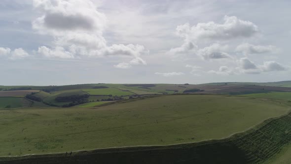 Aerial tracking back from the edge of the northern rampart of Maiden castle to reveal the size and g
