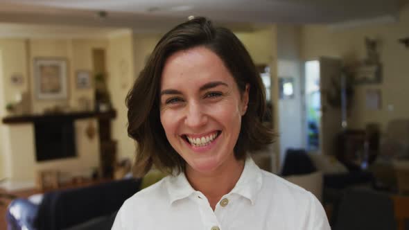 Portrait of smiling caucasian woman with brown hair in living room