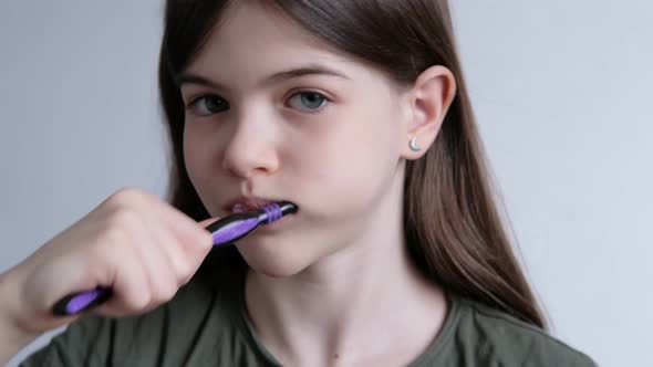 Little Beautiful Girl Brushes Her Teeth with a Toothbrush and Toothpaste