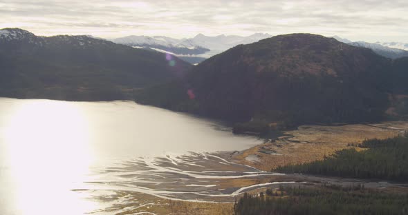 Aerial shot of Troopers helicopter flying over glacier, Alaskan mountains in background, drone