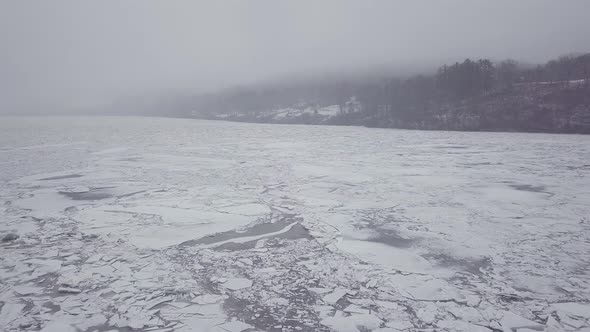 Drone flying above a foggy river with big ice chunks during a winter storm in Connecticut.