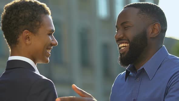 Afro-American Dad Hugging and Encouraging Teenage Son in Suit, First Interview