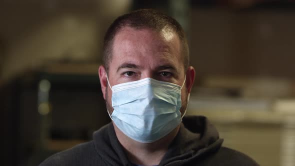 Man looking at camera as he wears faces mask for protection