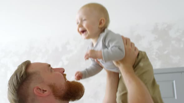 Happy Father Lifting Giggling Baby