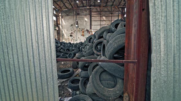 A bunch of car tires are in an abandoned factory. View of old factory inside. Close-up.