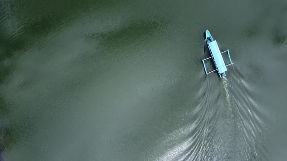 Aerial footage of a Small lonely motor boat along river