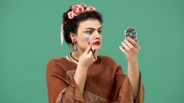 Portrait of Woman Style Icon and Famous Celebrity Frida Kahlo Painting Her Face with Brush and