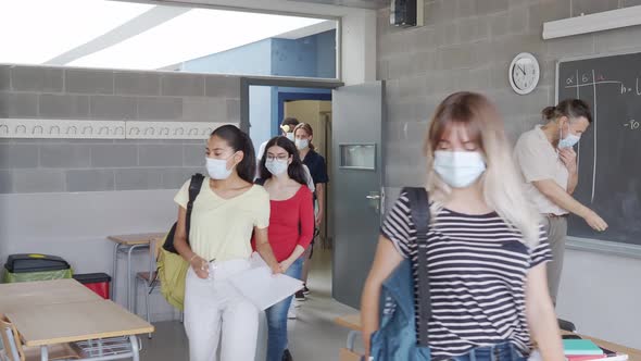 Group of Teenage Multiethnic Students and Teacher with Face Mask Into Class