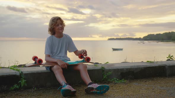 Silhouette Happy Child Portrait of Young Stylish Skater Boy Holding His Skateboard Outdoors