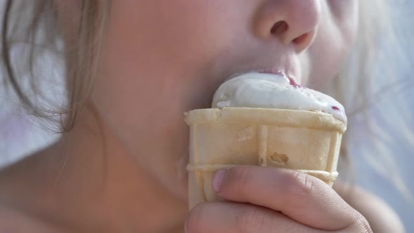 Small Girl Eats Icecream in Waffle Glass and Bites