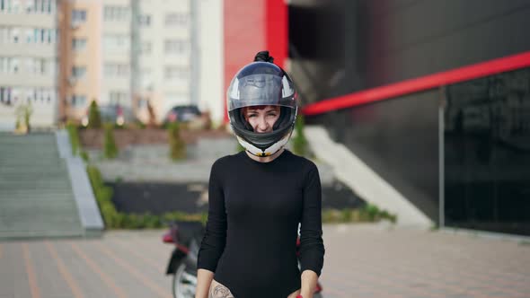 Biker sexy woman. Young beautiful redhead motocyclist woman wearing moto helmet