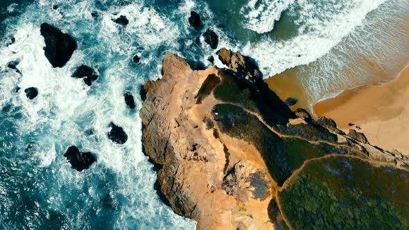 Aerila Top View of Ocean Waves Crashing Into Rocks Near the Coast of a California Beach