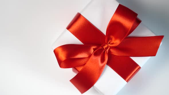 White Gift Box with Red Ribbon on White Background with Place for your Text