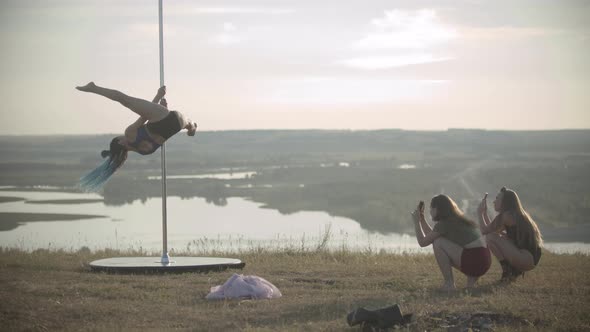 Woman Jumping on the Pole and Other Women Filming Her on Their Phones