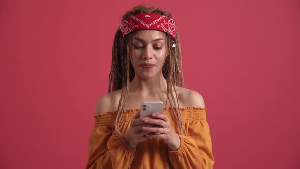 Cheerful hippie woman texting by phone